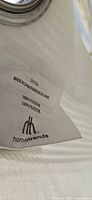 Close-up of fabric tag showing Hometrends brand, material, and origin