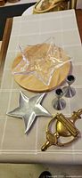 All items arranged: glass star bowl, wood board, aluminum star dish, two candlesticks, brass door knocker