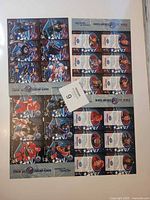 Two full uncut sheets showing card fronts and backs, maxsold lot tag visible