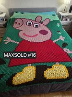 Full view of crocheted Peppa Pig blanket on queen bed