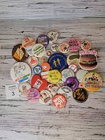 Group shot of entire collection of vintage buttons laid out on wood surface