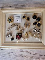 Framed display of all earrings and brooches together