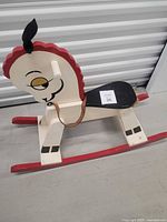 Left side view of painted wooden rocking horse