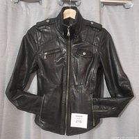 Front view of black leather jacket on hanger