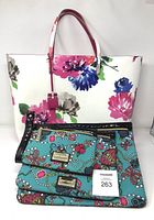 Front view of Kate Spade floral tote with three Betsey Johnson patterned clutches stacked