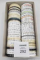 Box filled with stacked Letraset Letraline tape cassettes showing identifying labels on rims