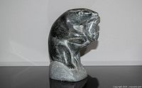 Front view of soapstone polar bear holding seal