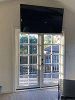 Front view of wall-mounted LG television above double doors