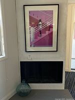 Overall view showing framed print above fireplace and glass demijohn bottle on floor