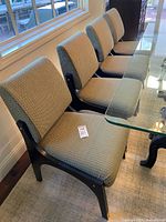 Four matching upholstered dining chairs around glass table