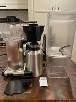 Full view of brewer, carafe, beverage dispenser on countertop