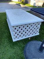 Full view of rectangular cast stone table on artificial turf showing overall design
