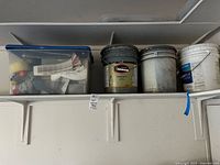 Overall view of tote and three paint buckets on shelf