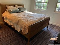 Bed frame assembled with mattress and pillows (bedding not included)