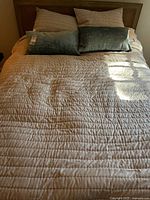 Full view of coverlet on bed with shams and lumbar pillows
