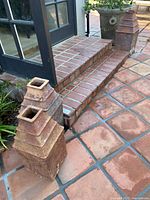 Two of the three square terracotta urn planters positioned by steps