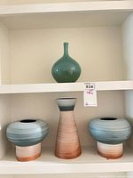 Shelf view showing green vase above three gradient band vases