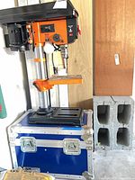 Full view of WEN drill press on top of blue hard case