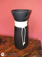 Full view of black glass vase with white rope accent