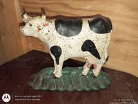 Front view of cast iron cow door stopper showing paint and overall condition