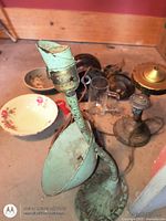 Green cast iron gooseneck lamp, brass-tone lamp base, black urn base, glass chimney and hardware visible