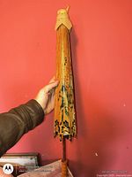 Folded parasol showing wood ribs and handle