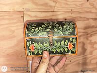 Front view of hand painted wooden chest showing floral design and latch