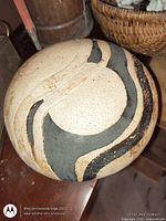 Top view of stoneware sphere showing carved dark swirl design