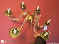 Top view showing six arms, central hub, brass finish, plastic wrap