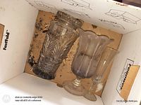 Top view showing three dirty glass vases inside box