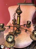 Overall view of chandelier showing central column, five arms with sockets, chain attached