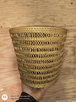 Side view of wicker waste basket showing looped weave design