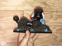 Front view of black ceramic poodle key hook showing four hooks and painted details