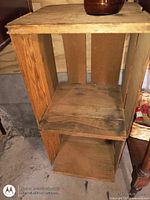 Full view of wooden crate standing upright, interior shelves visible