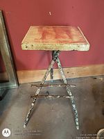 Full view of wooden plant stand showing square top and twig-style legs