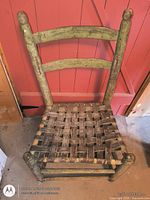 Front angled view of chair showing ladder back and woven seat