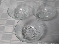 Three frosted floral glass bowls on table