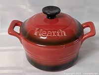 Front view of red ombre ceramic baking dish with lid showing side handles and knob