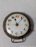 Front view of sterling silver antique watch showing dial, engraving and overall condition