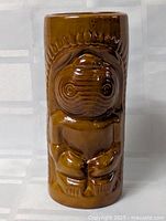 Full view of brown ceramic tiki vase front