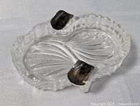Overall view of crystal ashtray, showing pattern and both sterling rests