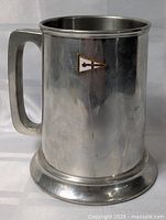 Front view of pewter tankard showing handle, base, and enamel yacht club burgee