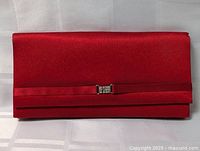 Front view of red satin clutch with rhinestone accent