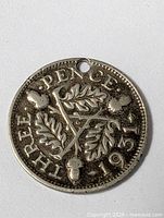 Reverse showing oak sprigs, denomination and date 1935 with drilled hole