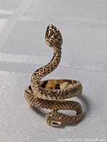 Front view of gold-tone snake ring showing coiled design and head detail