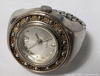 Front angled view of ring watch showing dial and bezel