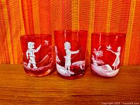 Front view of three cranberry tumblers