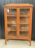 Full front view of mission oak china cabinet showing glass doors and shelves