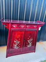 Full front view of red lacquer altar cabinet showing drawers, doors, inlay