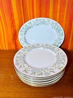 Stack of dinner plates with platter at back showing pattern